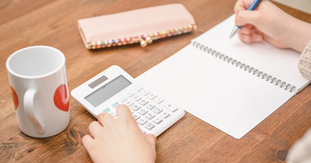 在宅介護にかかる費用を家計メモと電卓で整理している暮らしの一場面
