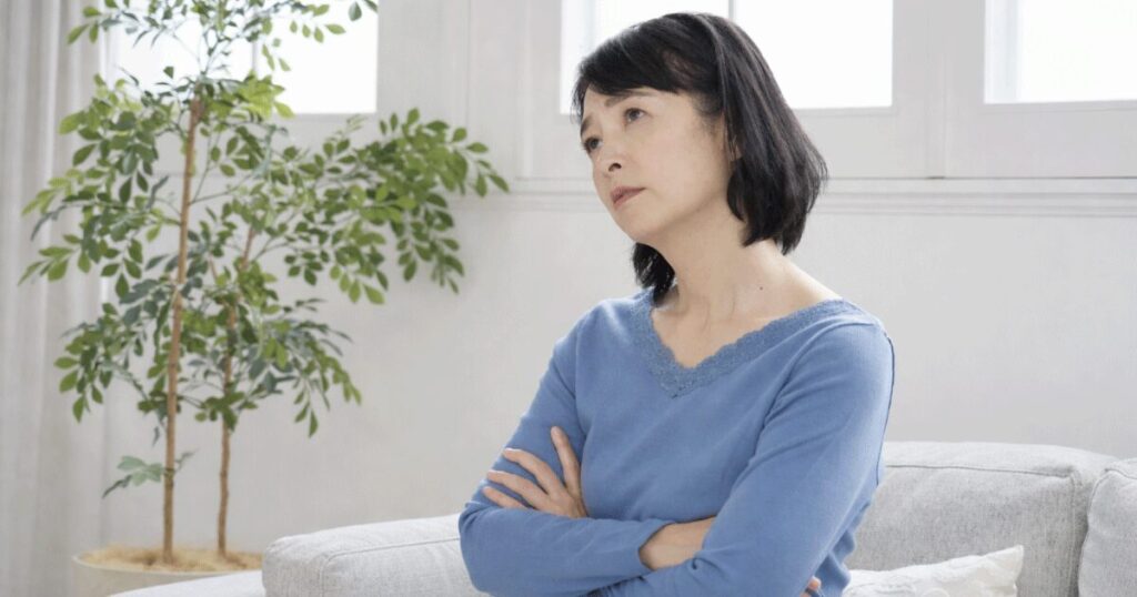 在宅介護を続ける中で、お金の不安や支援制度について考え込む介護者の様子